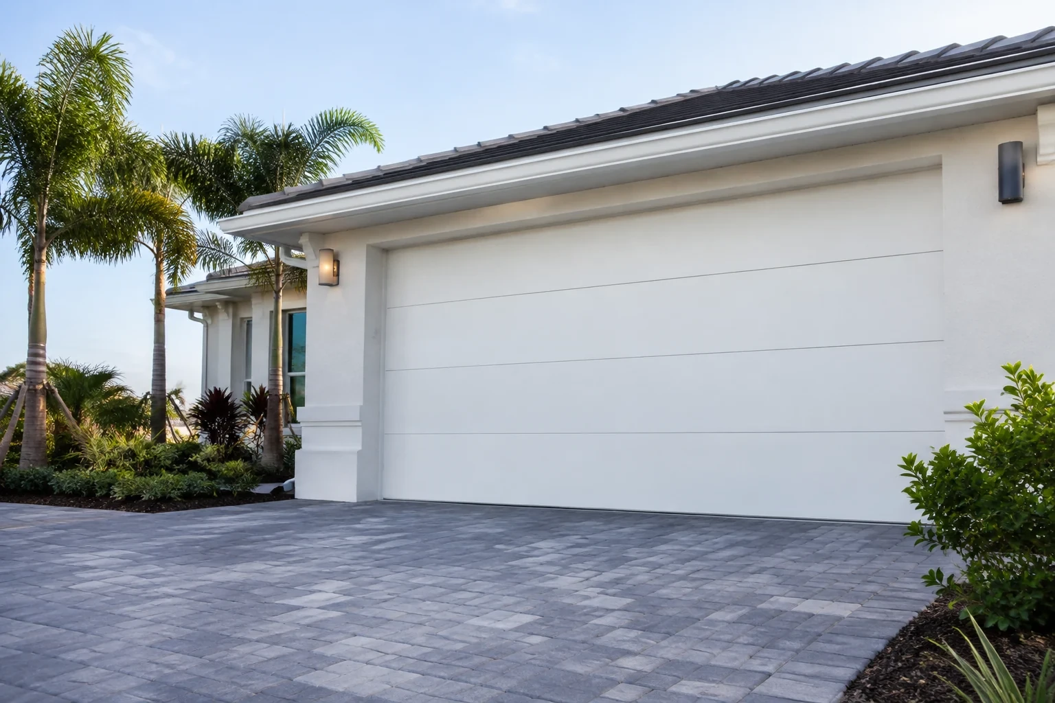 Closed sectional garage door on a landscaped house